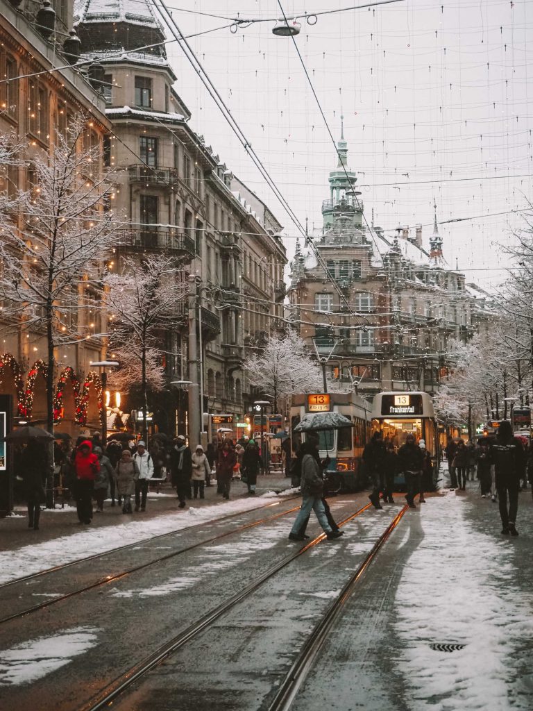 Illuminated tram lines and shop windows on Bahnhofstrasse in winter